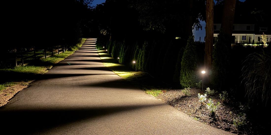 Long driveway lined with path lights at night