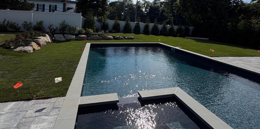 New pool with fresh lawn and boulders