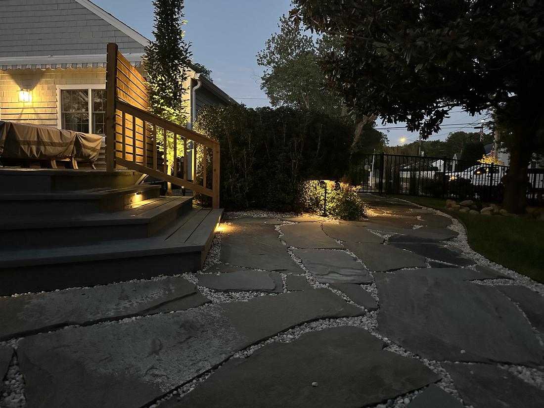 Deck and bluestone patio lit at dusk