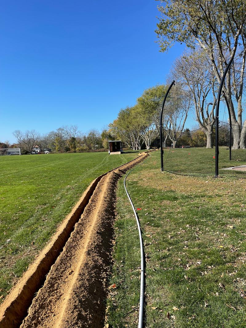 A narrow trench running across a lawn for a new line