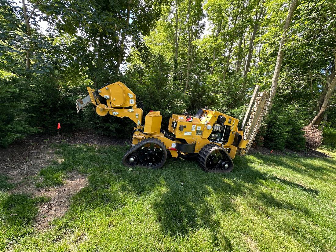 Tracked trencher in a wooded yard