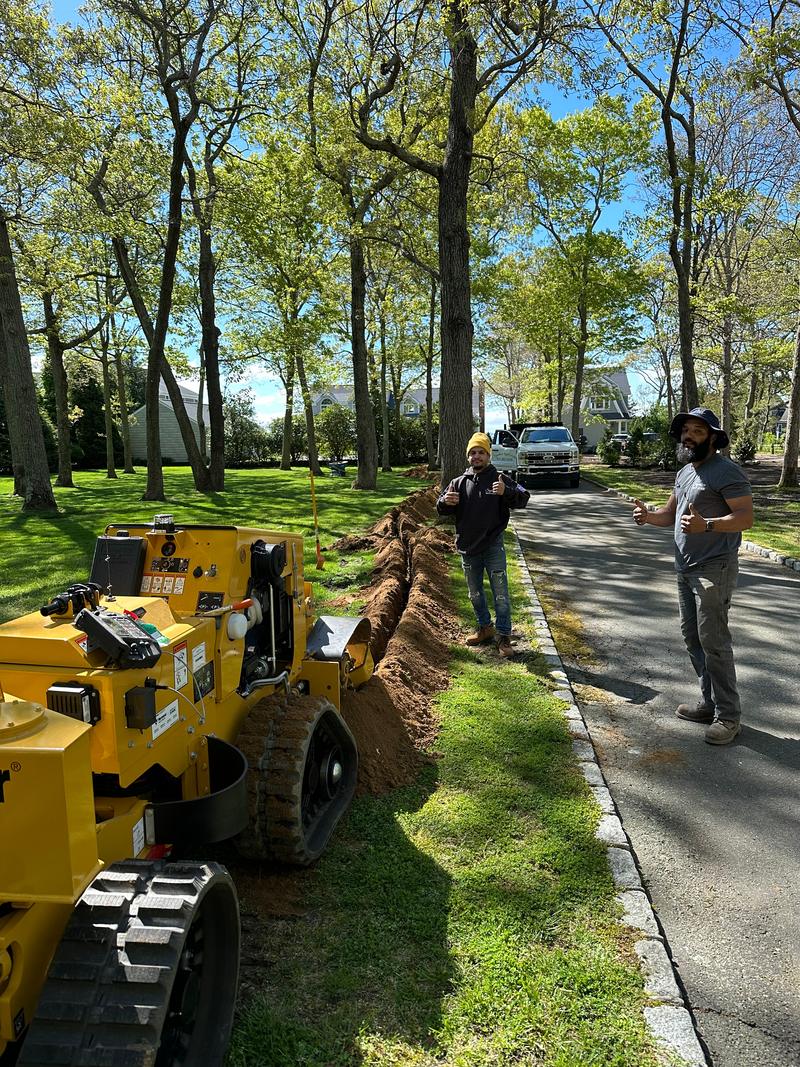 Tracked trencher working along a driveway